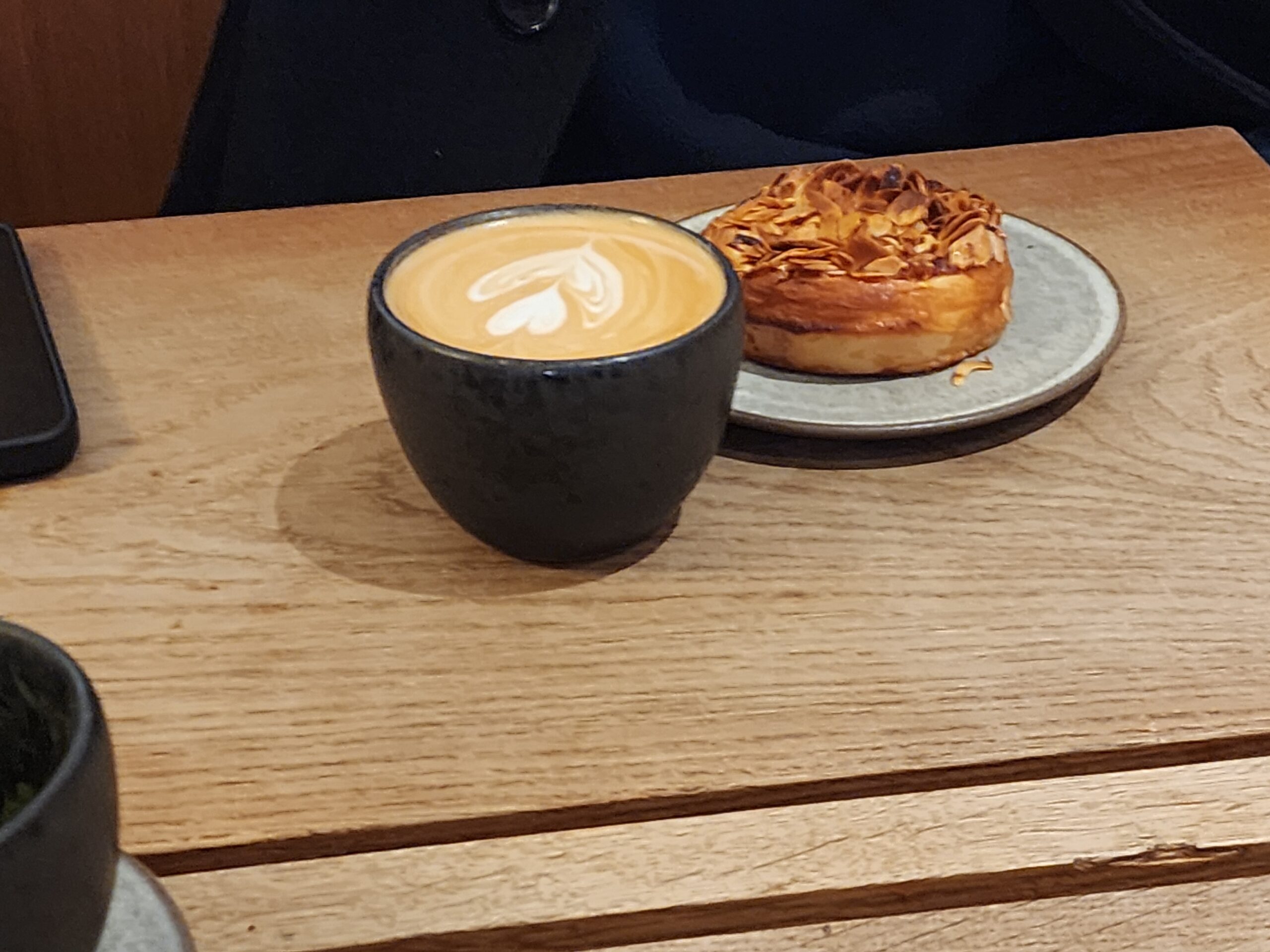 Flat White With Latte Art and an Almond Pastry