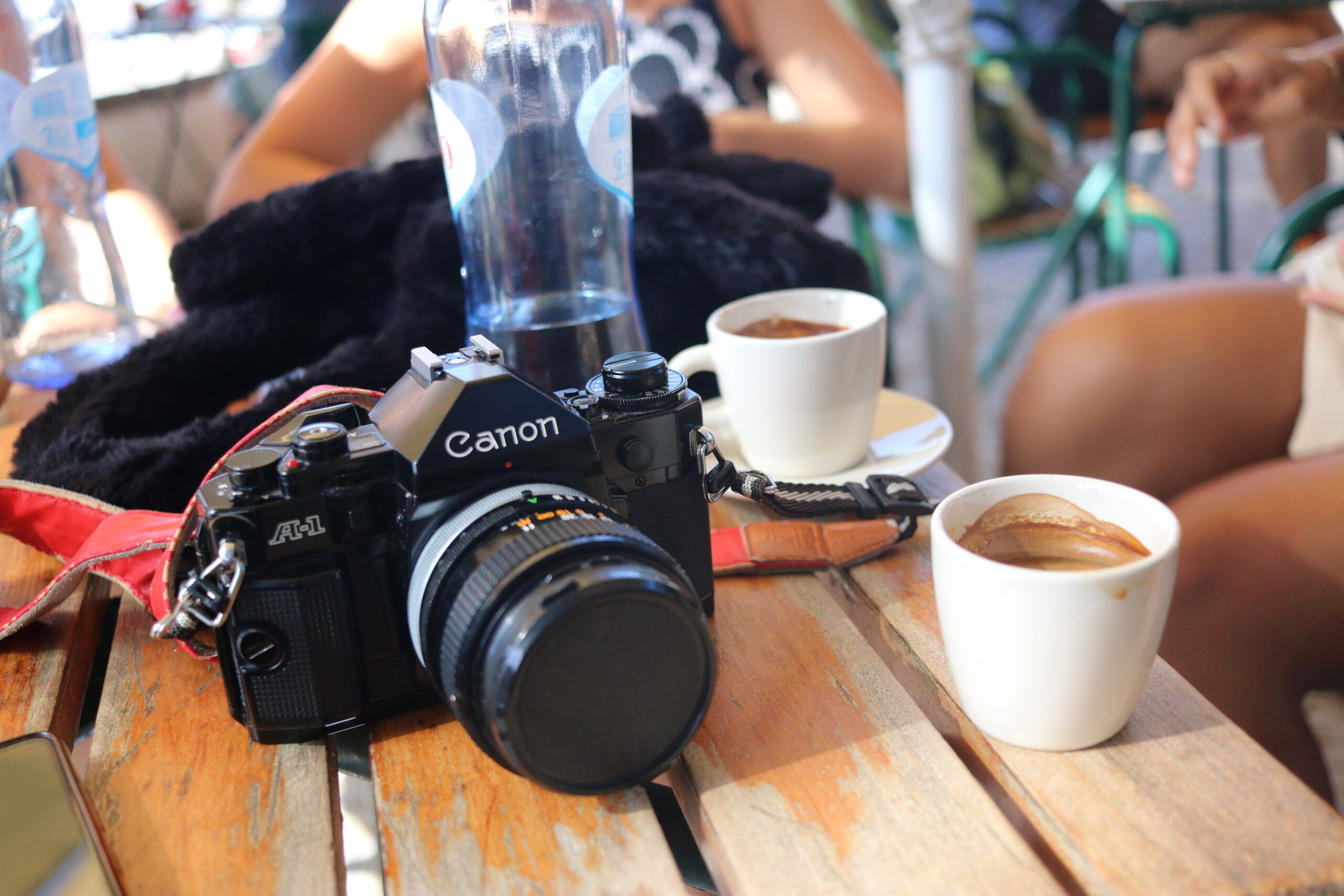 Canon A-1 Film Camera and Two Coffees on a Café Terrace